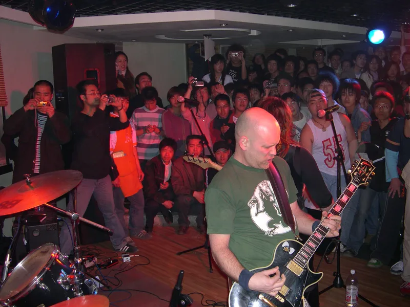 Kjell playing guitar at Bifengtang with the Xinxiang crowd photographing and filming from all sides
