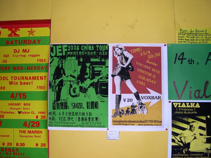 A wall of posters at VOX in Wuhan with the JEF 2006 China tour poster in the middle